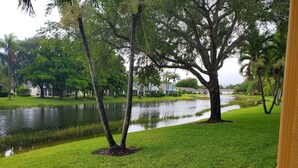 A residential area with a pond, trees, and houses in the background. - Parker Lakes Heated Pool, Spa and Sports Park <8 miles to Beach, Margaritaville. (Fort Myers)