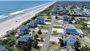 Vista aérea de una zona residencial costera con casas, una playa y una carretera.