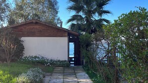A pathway leading to a wooden structure with a view of the sea. - Cabaña con Balcón y Vista al Mar (Concón)