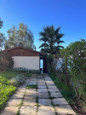A pathway leading to a wooden structure with a view of the sea. - Cabaña con Balcón y Vista al Mar (Concón)