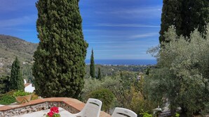 A terrace with a table and chairs, overlooking a scenic landscape with hills and the sea. - 4 bedrooms, sea views, and pure relaxation in Frigiliana. (Frigiliana)