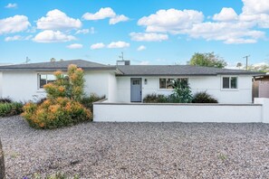 A modern two-story house with a white exterior, a gravel driveway, and a small tree in the front yard. - Closest Walk to Entertainment District (Scottsdale)
