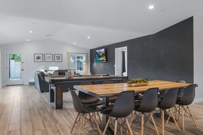 Une cuisine moderne avec une table à manger en bois et des chaises noires.