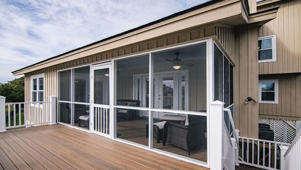 A covered patio with sliding glass doors, a wooden deck, and outdoor furniture. - Lost Options-Premier Home w/ Tidal Creek Dock; Creek/Marsh Views; Easy Beach Access (Edisto Beach)