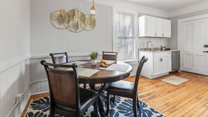 A dining area with a round table, chairs, and a decorative wall piece. - 1 Bed Luxury Downtown Columbia (Elmwood Park) (Columbia)