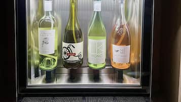 A refrigerated display case with four bottles of wine, each with a label and a price tag.