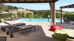 A covered outdoor area with a pool, lounge chairs, and bean bags. - Wonderful private villa for 4 guests with WIFI, private pool, A/C, TV, terrace and panoramic view (Noto)