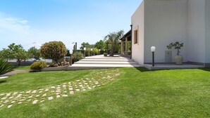 A modern building with a well-maintained lawn, a clear pathway leading to the entrance, and a pool in the background. - Wonderful private villa for 4 guests with WIFI, private pool, A/C, TV, terrace and panoramic view (Noto)