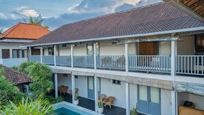 A two-story building with a balcony, a pool, and outdoor seating. - The Peacock Inn Ubud (Ubud)