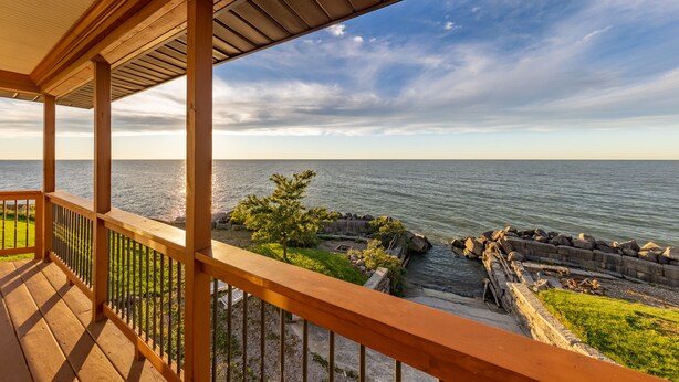 Une terrasse en bois offrant une vue sur la mer et un rivage rocheux.