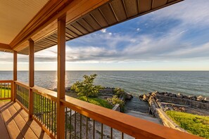 A wooden deck with a view of the sea and a rocky shoreline. - Lakefront cottage with amazing views (Willowick)