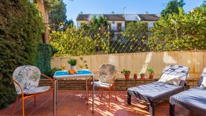 An outdoor patio with a table, chairs, and lounge chairs. - Adelfas 14 - Beach, Terrace, Pool, 2 Bedrooms (Torremolinos)