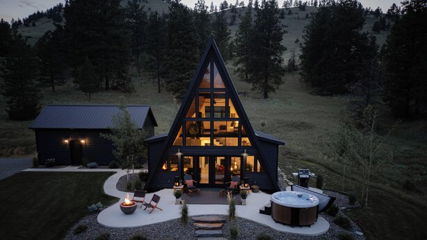 A modern A-frame house with a hot tub and outdoor seating area. - Secluded Montana A-Frame with Hot Tub and Views (Jefferson City)