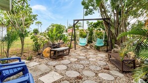 Un patio jardín con un columpio, un banco y un sendero de piedra.