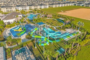 Parque acuático con toboganes y piscinas, rodeado de edificios residenciales.