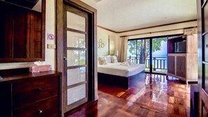 Een slaapkamer met een groot bed, een dressoir, een televisie en een balkon met uitzicht.