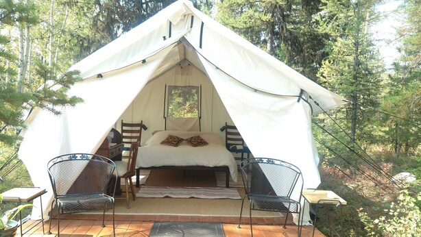A tented accommodation with a bed, two chairs, and a window. - Glamping tent 1, remote with Glacier Park Mountain views. 5mins from Polebridge  (Polebridge)