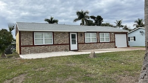 A single-story house with a stone facade, a garage, and a small attached shed.