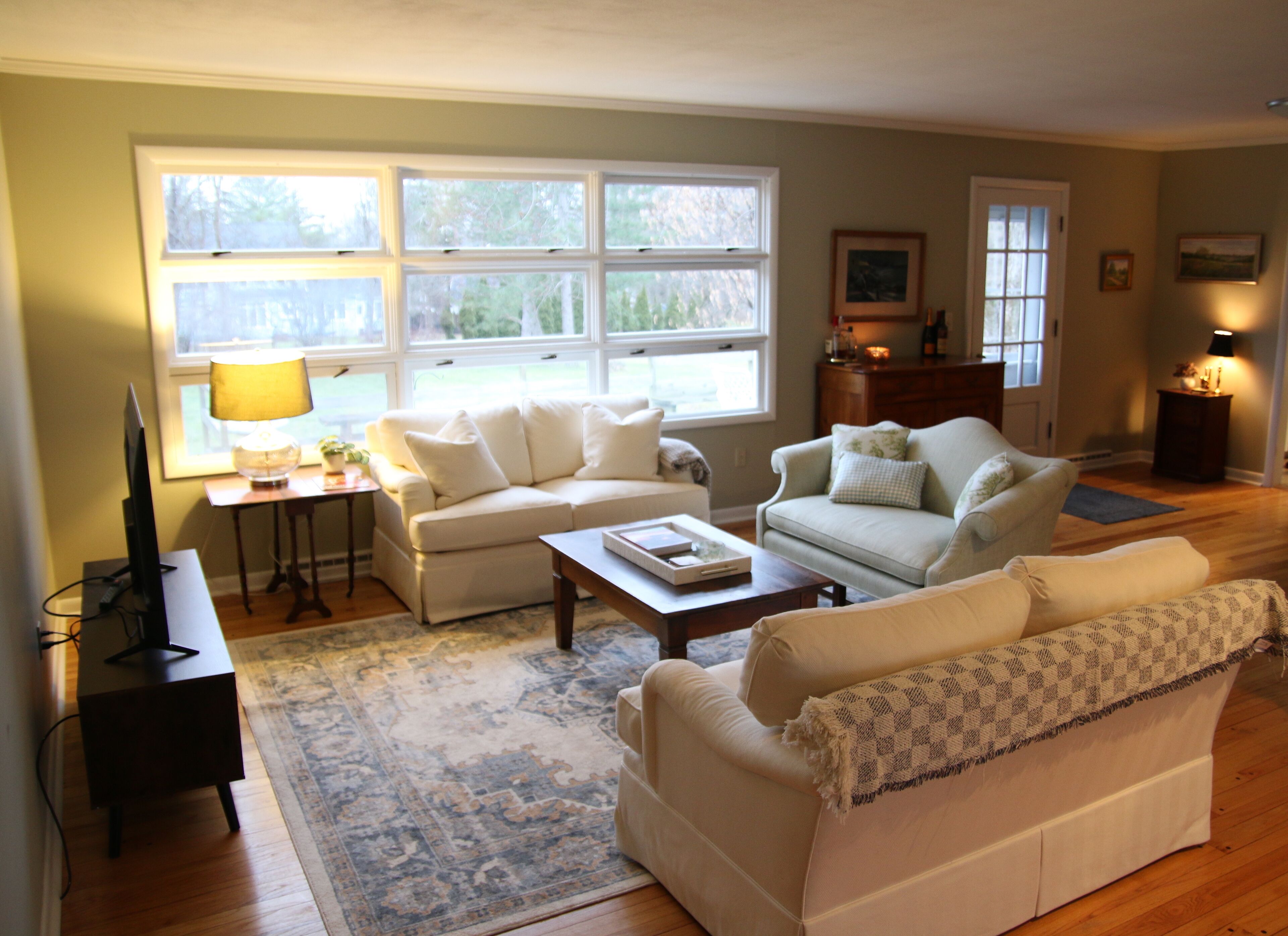 A living room with a sofa, a coffee table, a TV, and a lamp.