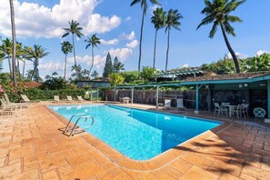 Ein rechteckiger Swimmingpool mit glasklarer, blauer Wasserfläche, umgeben von einer Pflasterterrasse.