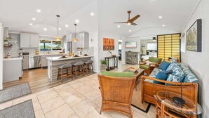 A spacious living area with a sofa, a dining table, and a kitchen in the background.