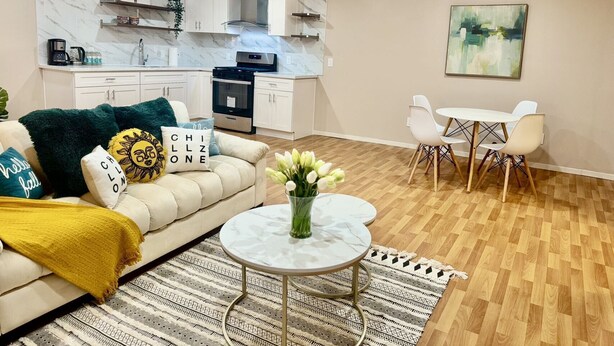 Una sala de estar moderna con sofá, mesa de centro y comedor.