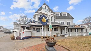 A waterfront eatery with a distinctive ice cream cone sign, a covered porch, and a brick pathway leading to the entrance. - Modern Beachside Condo in Onset Village: Walk to Dining, Market & Beaches Monthly Rates Available (Onset)