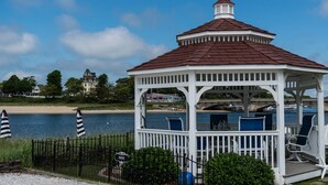 A white gazebo with a red roof, located near a body of water. - Modern Beachside Condo in Onset Village: Walk to Dining, Market & Beaches Monthly Rates Available (Onset)
