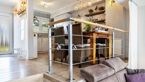 A modern interior with a dining area, wicker chairs, a cushioned bench, and a kitchen in the background. - Edersee-Scheid Apartment with Lake View, Private Terrace & Wi-Fi (Waldeck-Scheid)