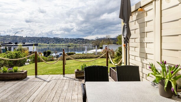 A deck with a table and chairs, overlooking a lake and a town. - Edersee-Scheid Apartment with Lake View, Private Terrace & Wi-Fi (Waldeck-Scheid)