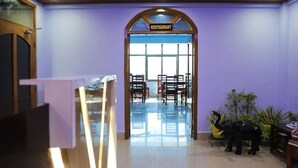 Entrada a un restaurante con un letrero, piso de madera y sillas.