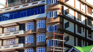 Un edificio de varios pisos con balcones, ventanas amplias y una fachada de piedra distintiva.
