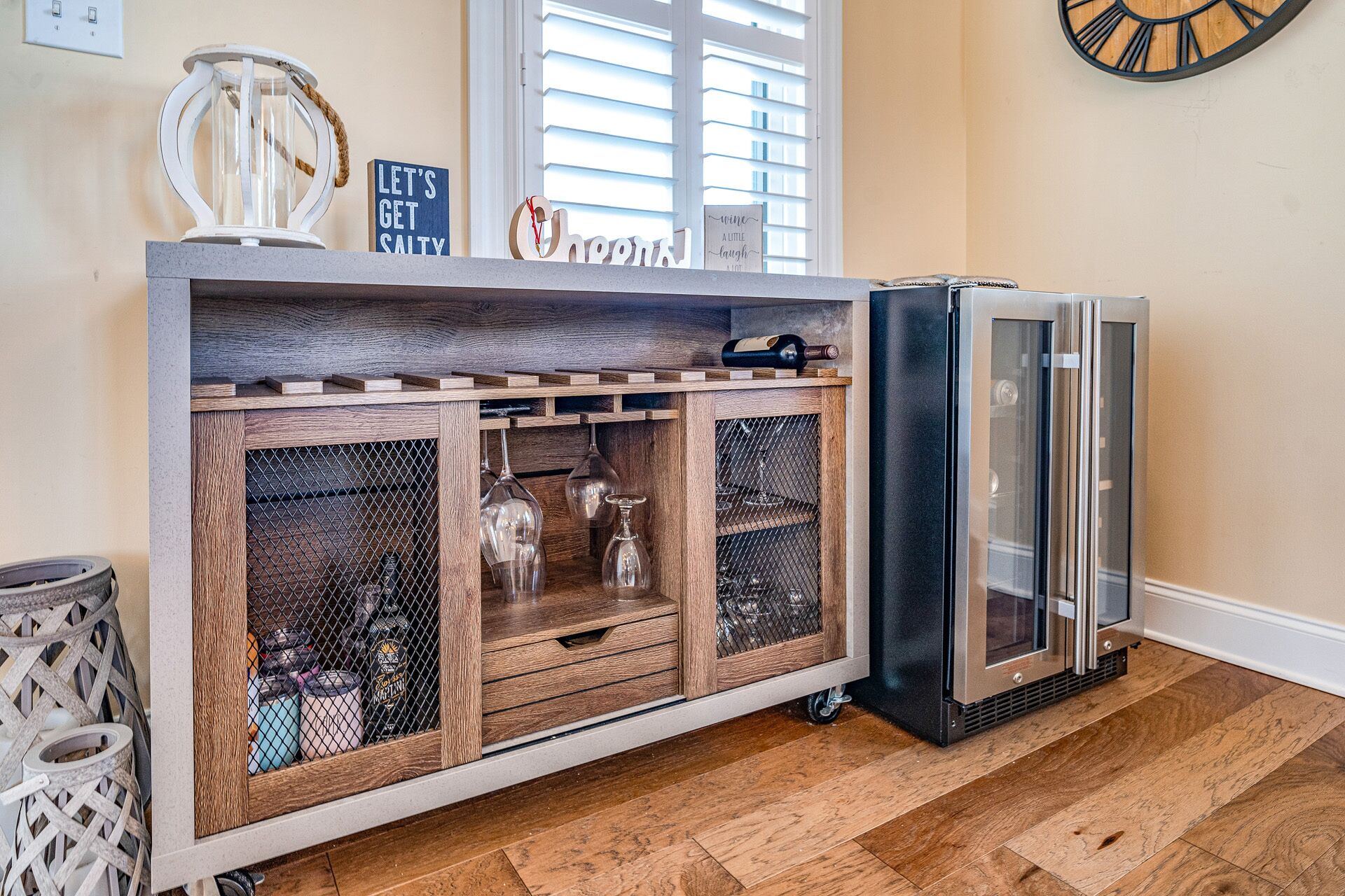 A kitchen with a wooden cabinet, a wine bottle, and a refrigerator.