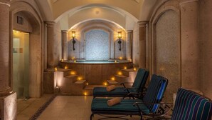 A spa area with stone columns, a mosaic wall, and lounge chairs. - Oceanview 2BR/2BA Presidential Suite at Sunset Beach Oceanfront Resort, Golf Spa (Cabo San Lucas)
