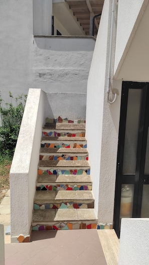 A staircase with colorful mosaic steps leading to a door. - L Appoggio - Monolocale Eco-sostenibile a due Passi dal Centro Storico (Corsano)