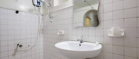 Un baño con un lavamanos blanco, un espejo y una ducha.