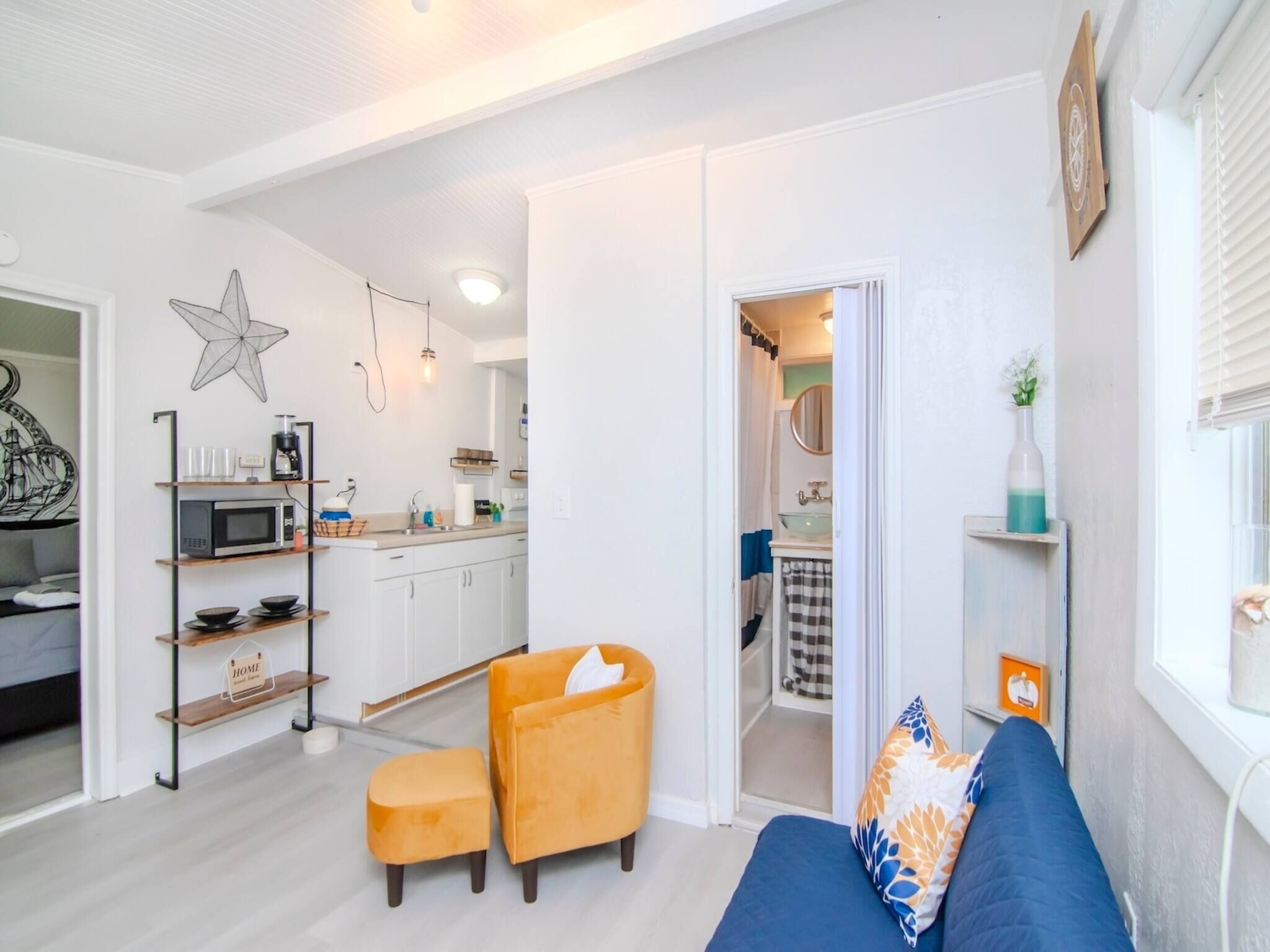 A modern living room with a sofa, ottoman, and a star decoration on the wall.