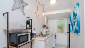 A compact kitchen with a microwave, coffee maker, and a starfish decoration on the wall. - The Cottage in Clearwater - 30 Day Minimum Stay (Clearwater)