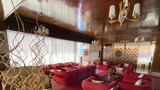 A spacious living area with red sofas and a patterned carpet. - THE ROSE OTEL (Ankara)