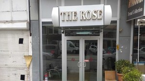 A storefront with a sign reading "THE ROSE" and a glass door entrance. - THE ROSE OTEL (Ankara)