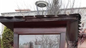 A soldier in a glass booth with a vehicle in the background. - THE ROSE OTEL (Ankara)