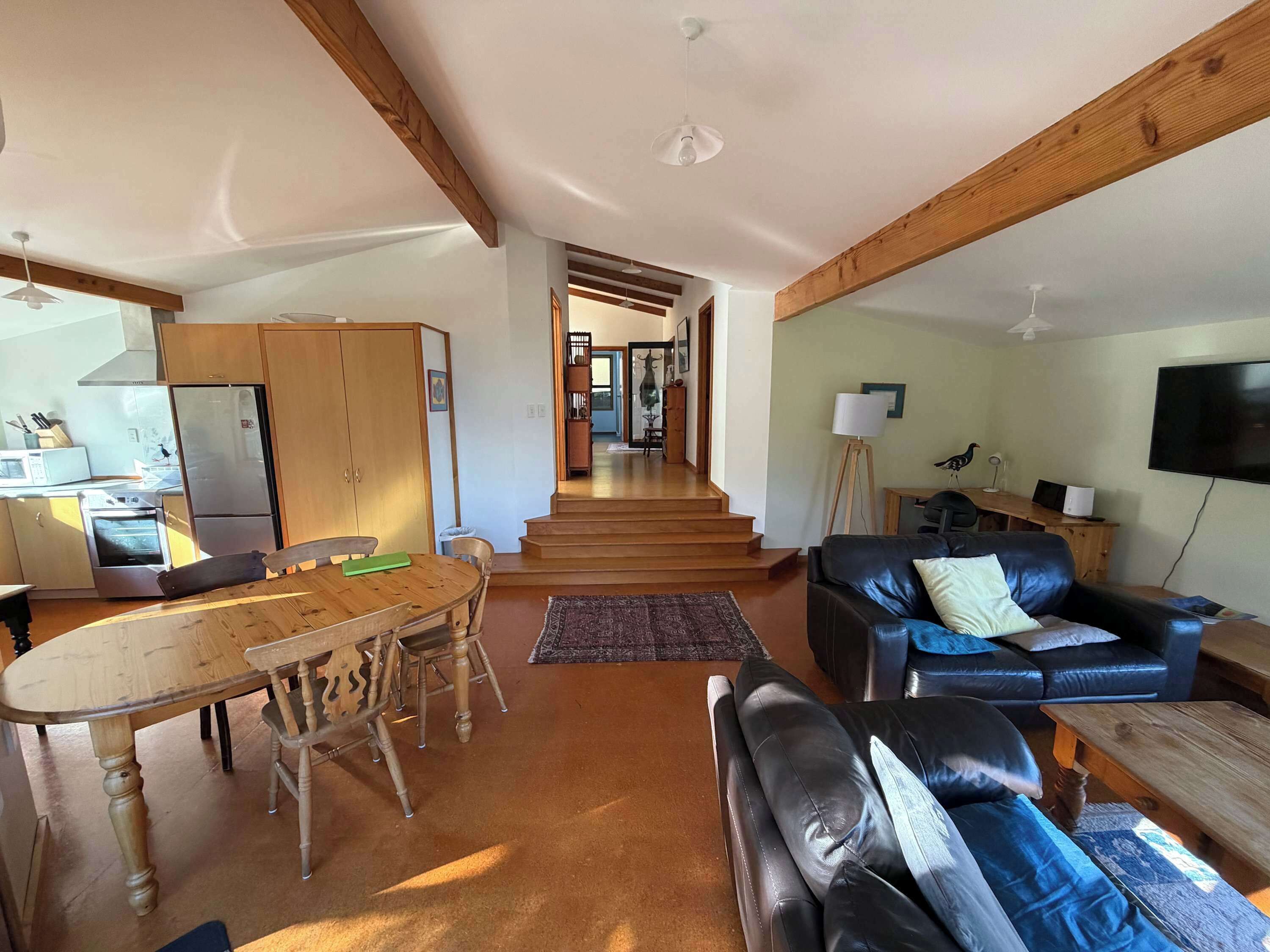 Amplia sala de estar con mesa de comedor, sofá y área de cocina equipada.