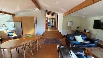 Amplia sala de estar con mesa de comedor, sofá y área de cocina equipada.