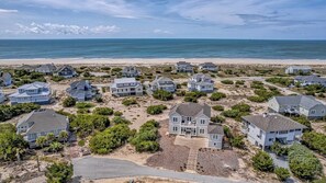 Zona residencial costera con casas, una playa y cielo despejado.