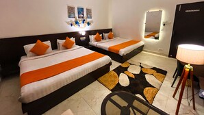 A hotel room with two beds, a ceiling fan, a mirror, and a rug.