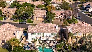 A residential area with multiple houses, a swimming pool, and a well-maintained lawn. - 6th Tee Luxury | Pool & Fire Pit (Chandler)
