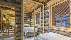 A log cabin bedroom with a mirrored wardrobe, a wooden staircase, and a large window with blinds. - Menninkäisenkolo by Interhome (Äkäslompolo)
