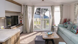 A modern living room with a sofa, a coffee table, and a TV. - Bay View (Bembridge)
