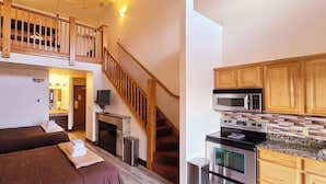 Een slaapkamer met twee bedden, een trap en een keuken met houten kastjes en moderne apparaten.