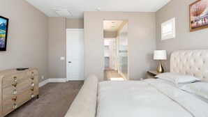 Ein Schlafzimmer mit Bett, Schminktisch und einem Bild an der Wand.